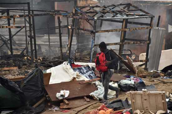 لاجئ وسط الدمار بعد حريق المخيم